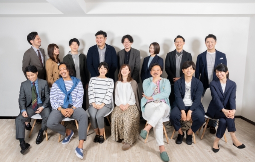 株式会社イズル 代表取締役の中田潤一とコンサルタント、スタッフが、前に7人椅子に座り、後ろに8人立って笑顔あふれる和やかな集合写真
